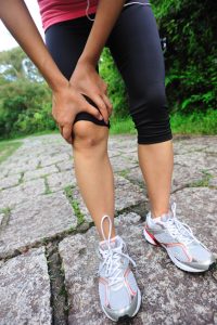 woman runner hold her sports injured knee