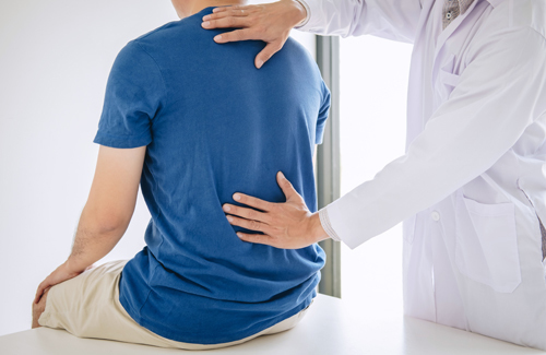 A doctor examines a patient's spine